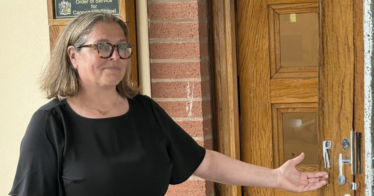 Rosie Sayers, funeral celebrant, wearing black outside the chapel at Canley Crematorium, welcoming guests.